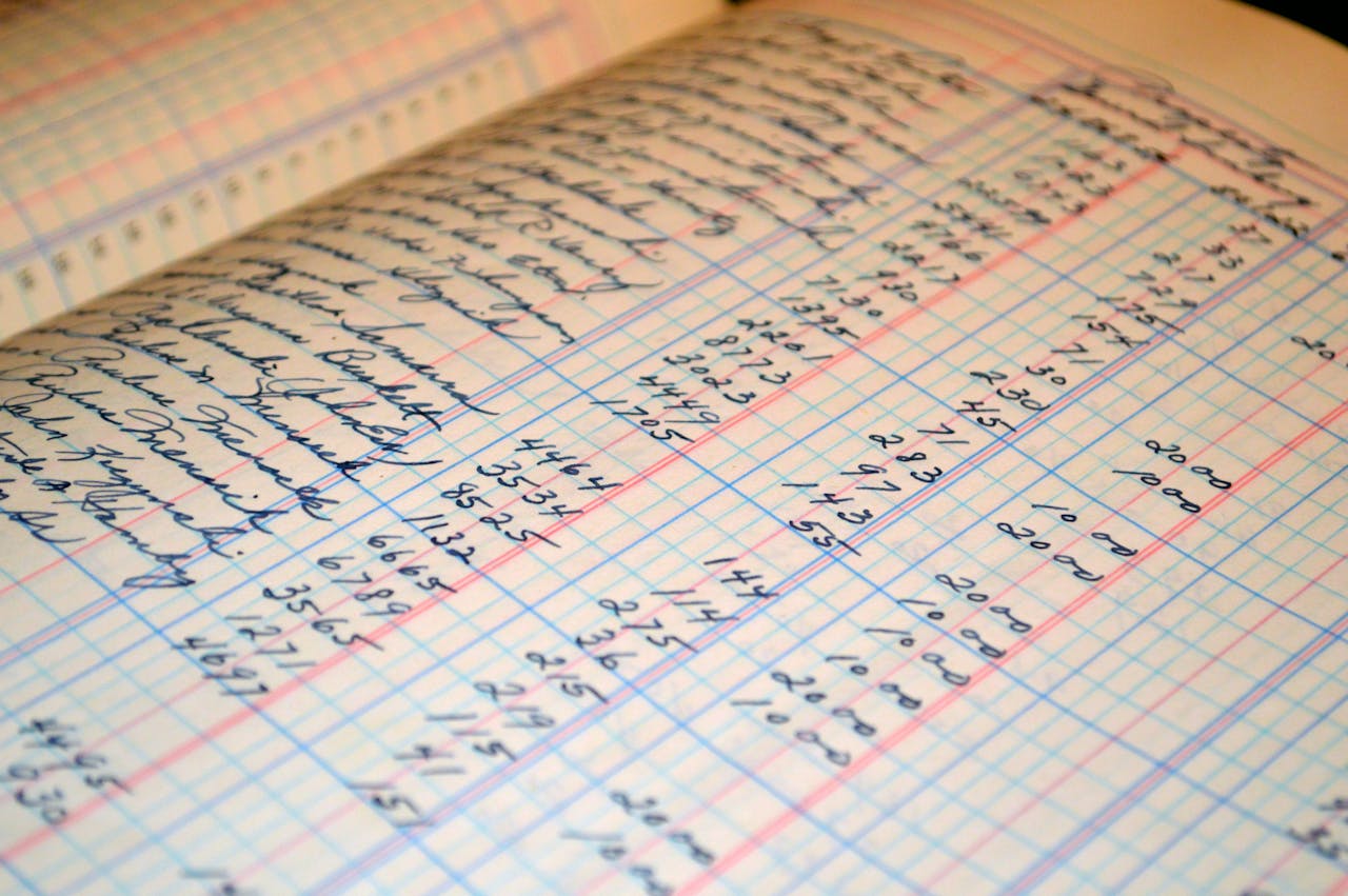 about-us-02 Close-up of a vintage handwritten ledger detailing financial records and accounts.